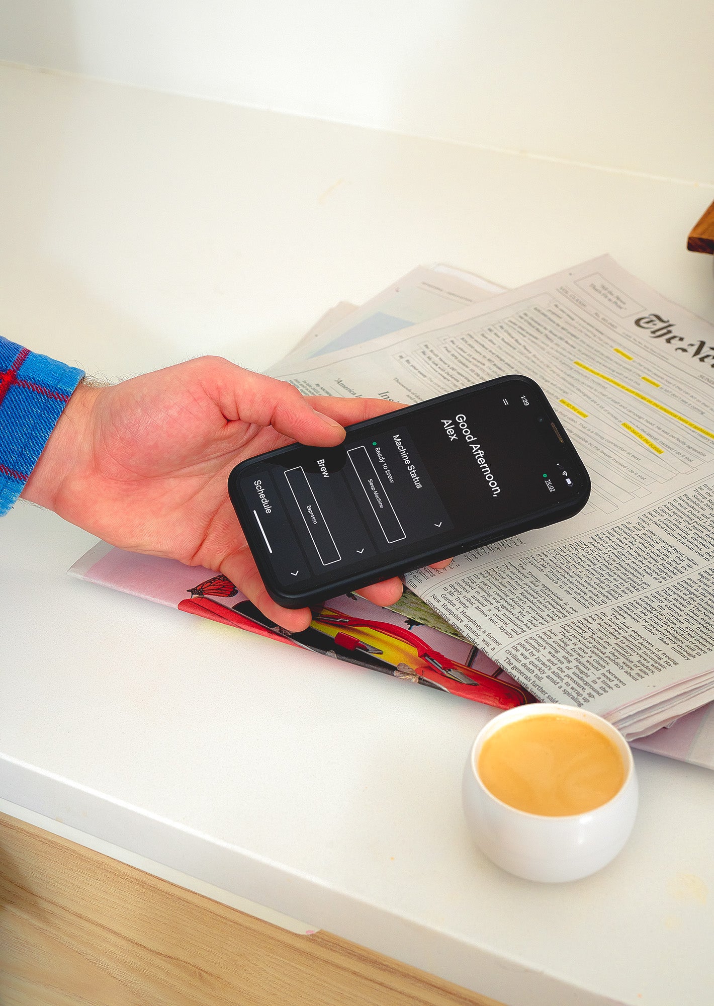 A hand holding a phone with the Terra Kaffe App open