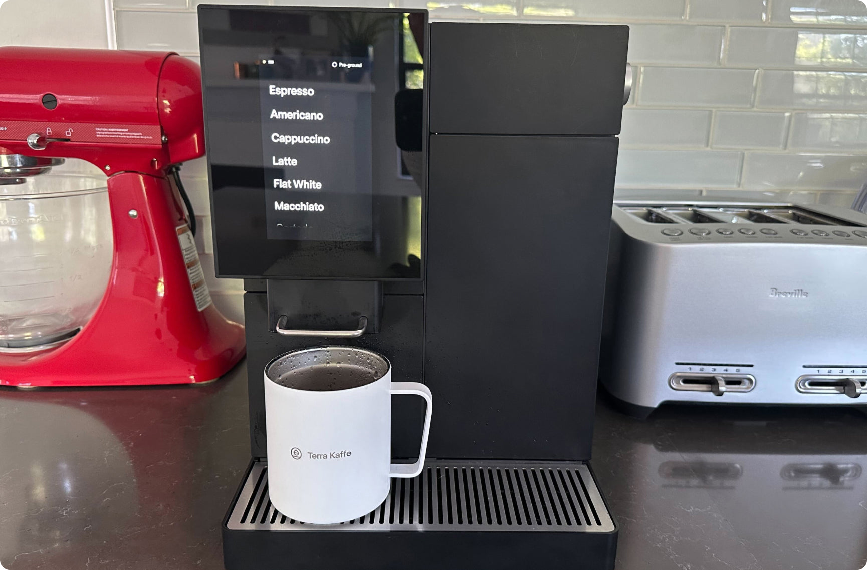 Terra Kaffe | Black TK-02 on a black countertop with a white Terra Kaffe mug